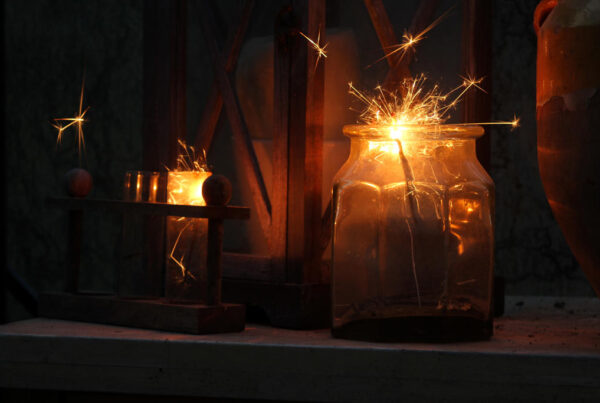 Dark lit shelf with glass jar containing sparkler